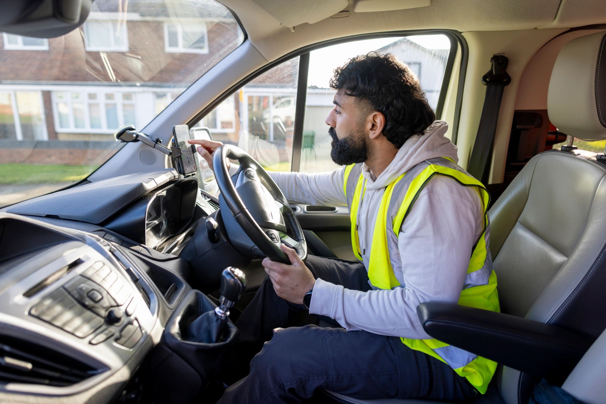 Driver using phone in car while reviewing route and documents